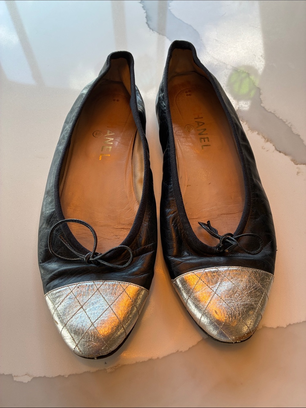 CHANEL Black Leather Ballet Flats with Silver Quilted Cap Toe